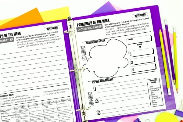 Open purple binder with worksheet pages for writing exercises, pencils, and colorful paper. The visible worksheet focuses on brainstorming Kids Writing Prompts and planning a paragraph, with sections for organizing ideas and reasons.